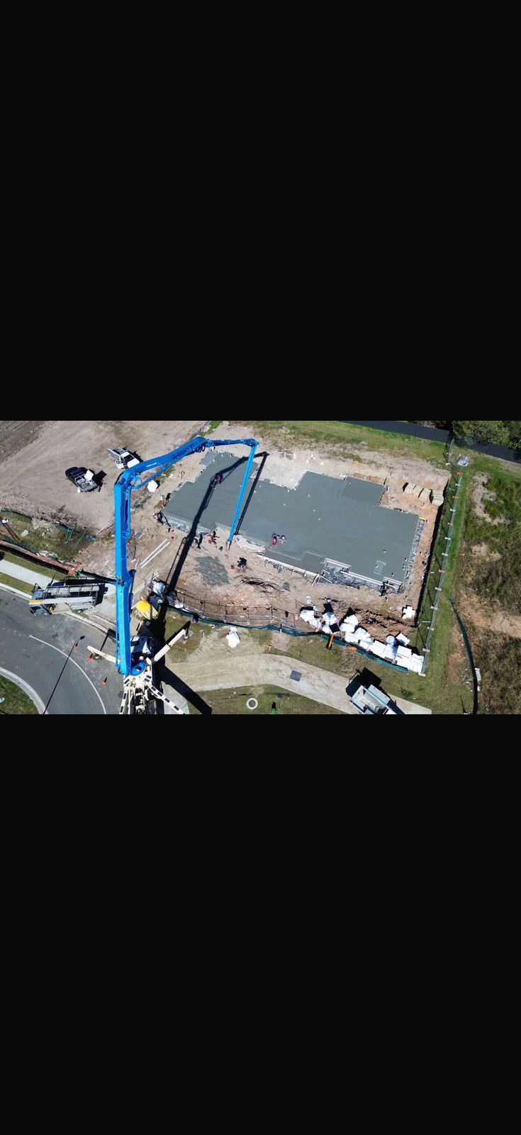 Aerial view of house slab pour with concrete pump truck
