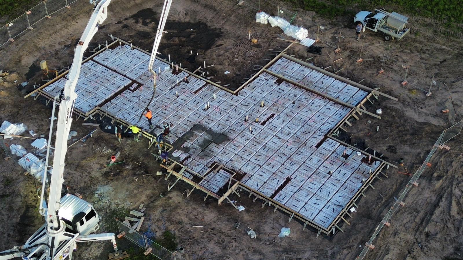 Aerial view of house slab pour with pump truck