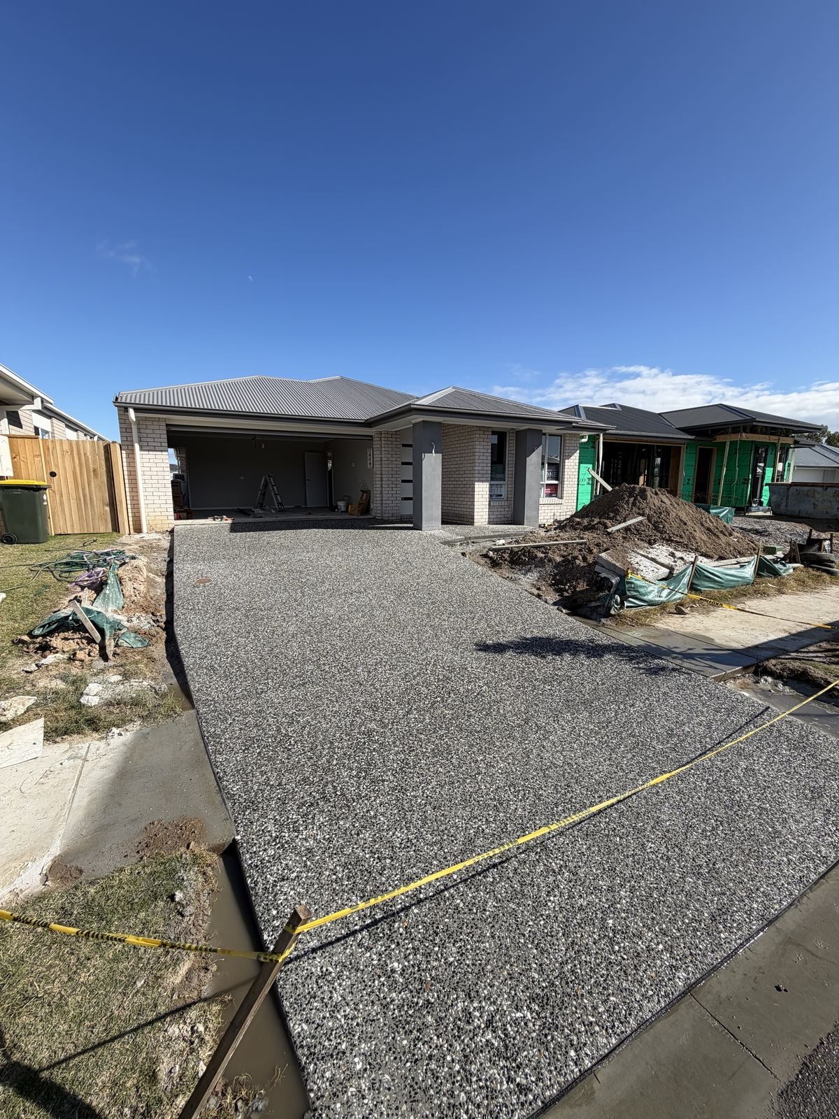 Finished exposed aggregate driveway leading to new home