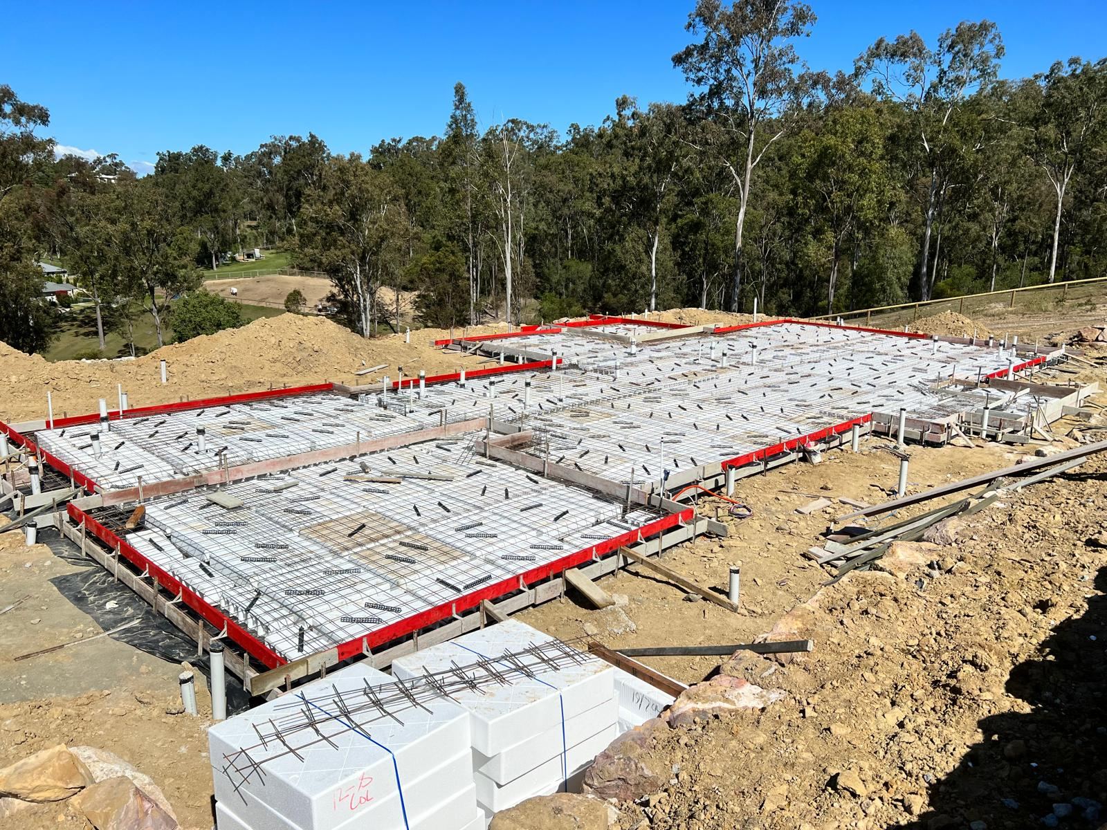Aerial view of dual house slab pours in a bushland block