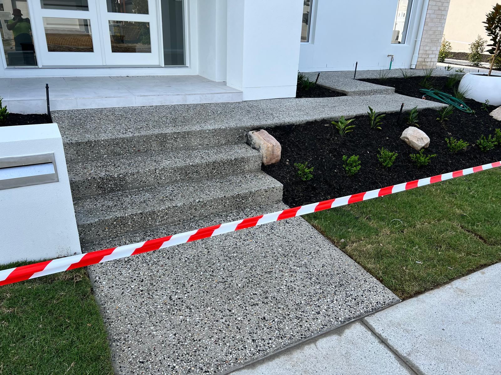 Exposed aggregate entry steps with garden landscaping