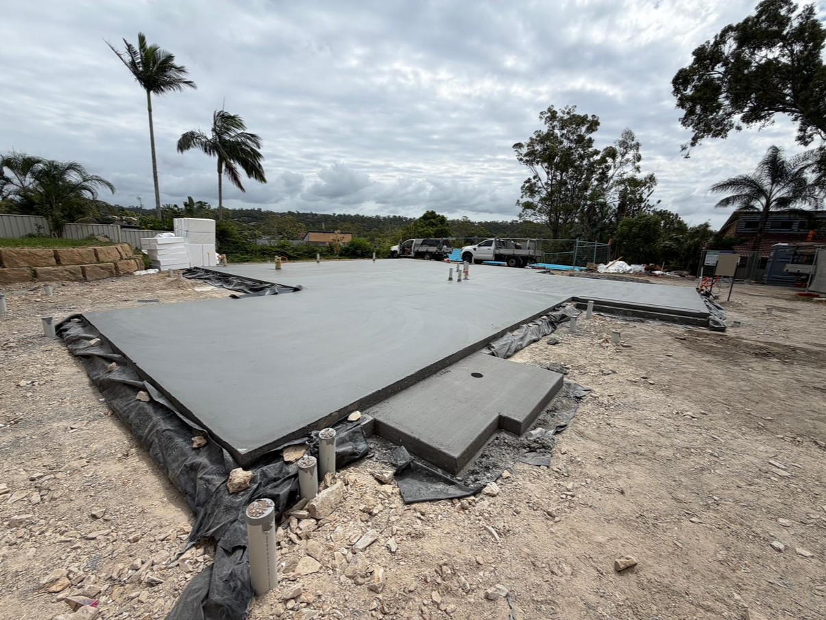 Freshly poured house slab with formwork, overcast sky