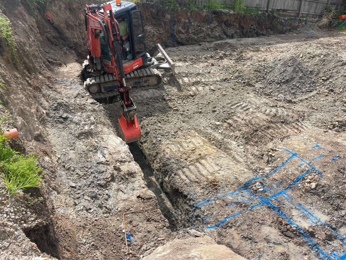 Excavator trenching for footings along a boundary line