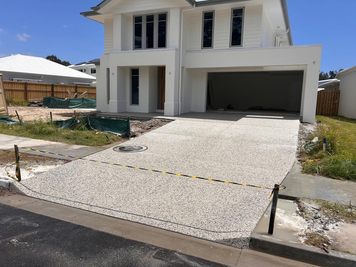 Completed exposed aggregate driveway leading to double garage