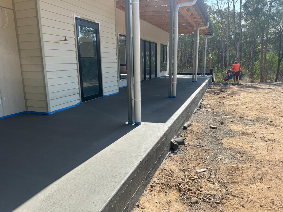 Charcoal exposed aggregate alfresco patio with timber posts